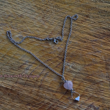 Rose Quartz Heart Shaped Pendant Necklace Small size with a small stainless steel heart on the bottom . Rose Quartz Heart Shaped Pendant Necklace Small size with a small stainless steel heart on the bottom .